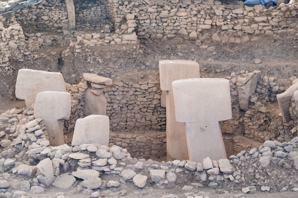 Archaeologists uncovering layers of earth at the Göbeklitepe excavation site.